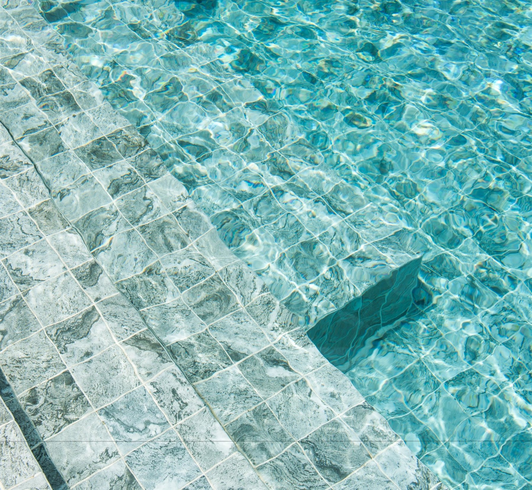Clear blue spa water over pale stone